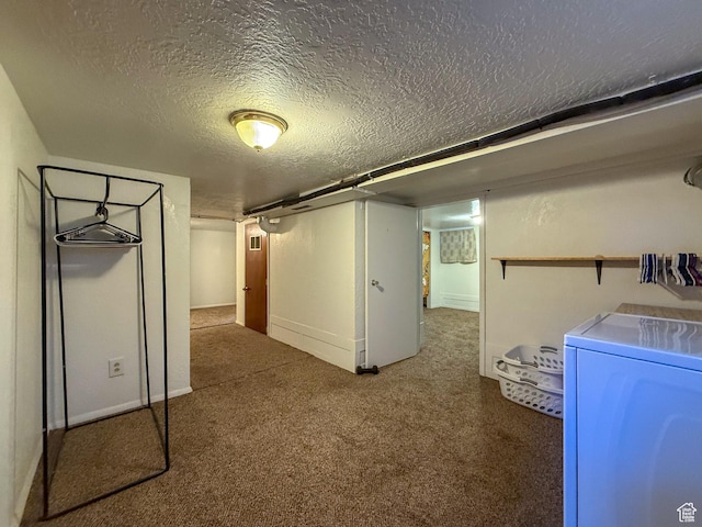 finished below grade area featuring a textured ceiling, washer and dryer, and carpet flooring