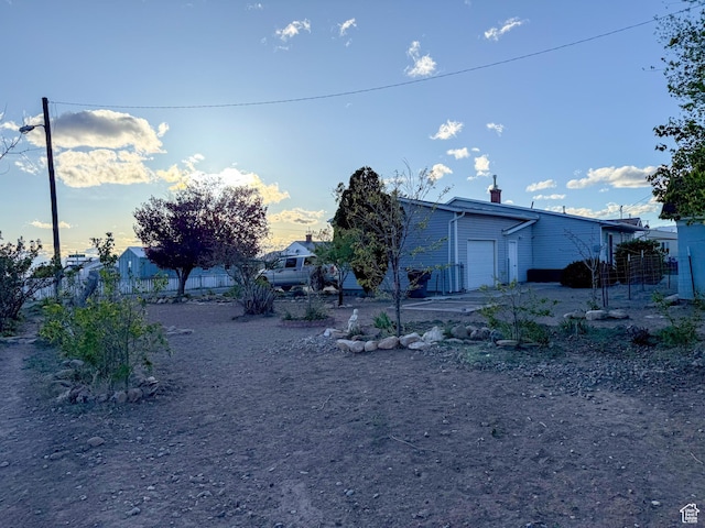 view of yard featuring an attached garage and fence