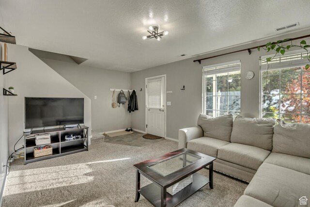 living room with carpet flooring, baseboards, and a textured ceiling