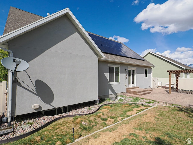 3263 W Blue Moon Ln, South Jordan, UT 84095 - rear view of house featuring roof mounted solar panels, stucco siding, a pergola, and roof with shingles