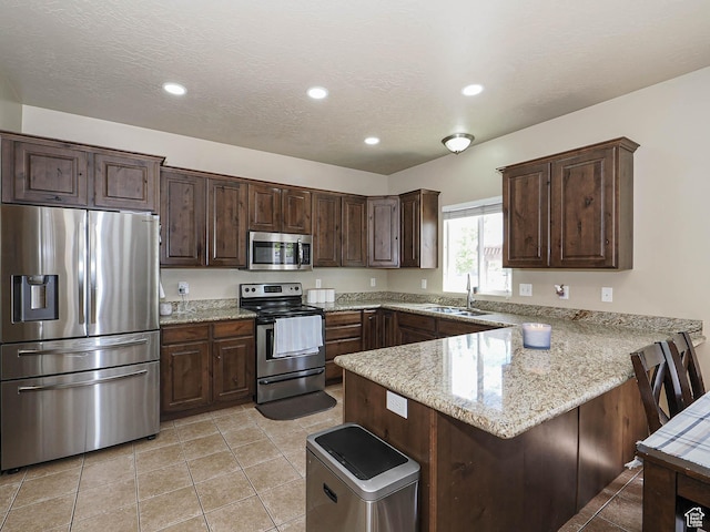 3263 W Blue Moon Ln, South Jordan, UT 84095 - kitchen featuring stainless steel appliances, a sink, a peninsula, dark brown cabinetry, and recessed lighting