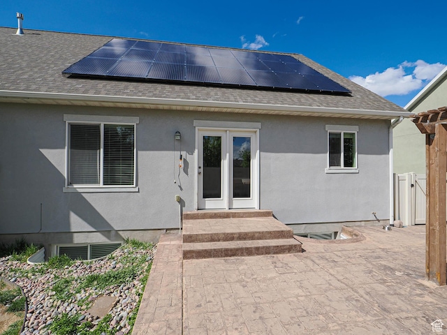 3263 W Blue Moon Ln, South Jordan, UT 84095 - view of exterior entry featuring roof with shingles, roof mounted solar panels, and stucco siding