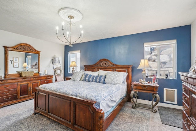 bedroom with light colored carpet and a chandelier