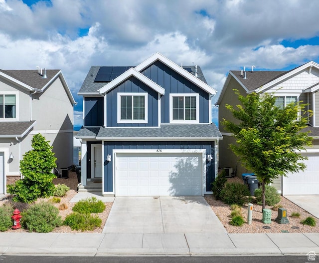 876 S Brubaker Way, Santaquin, UT 84655 - view of front facade featuring board and batten siding, solar panels, concrete driveway, a garage, and central AC