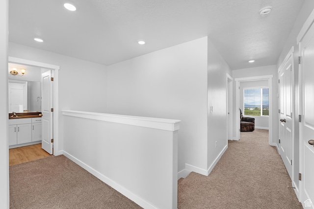 876 S Brubaker Way, Santaquin, UT 84655 - hall featuring light carpet, an upstairs landing, recessed lighting, baseboards, and a sink
