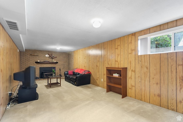 living area with carpet, wood walls, a fireplace, and a textured ceiling