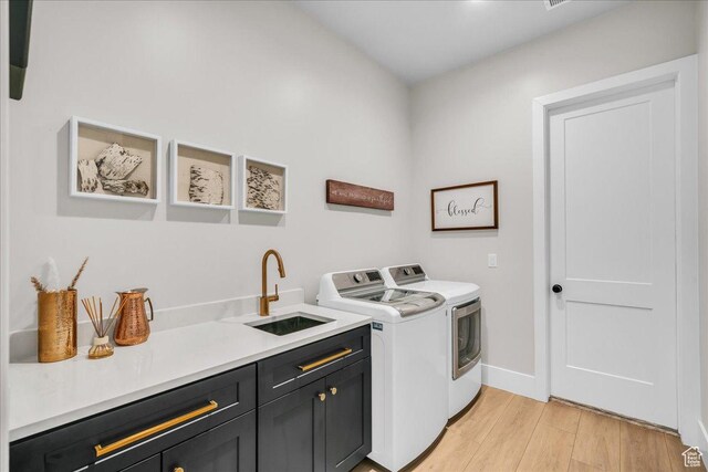 1003 N Grand Heights Dr, St George, UT 84770 - washroom featuring cabinet space, washing machine and clothes dryer, light wood-type flooring, and baseboards