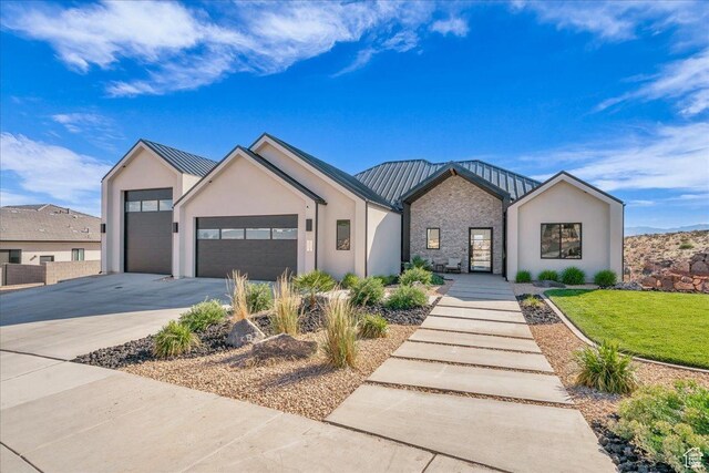 1003 N Grand Heights Dr, St George, UT 84770 - view of front of property featuring driveway, an attached garage, a standing seam roof, and stucco siding