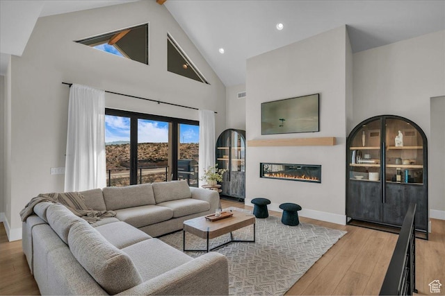 1003 N Grand Heights Dr, St George, UT 84770 - living area featuring high vaulted ceiling, wood finished floors, baseboards, a glass covered fireplace, and recessed lighting