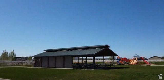 rear view of house featuring a yard, a playground, and a gazebo