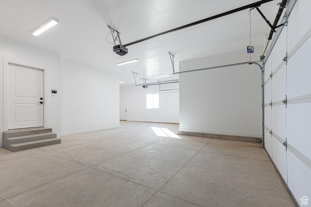 garage with a garage door opener and baseboards