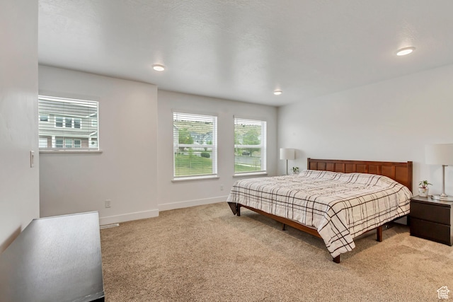 bedroom featuring light carpet, baseboards, and recessed lighting