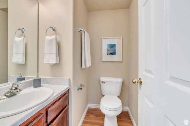 1140 E Elgin Ave S, Millcreek, UT 84106 - bathroom featuring toilet, wood finished floors, baseboards, and vanity