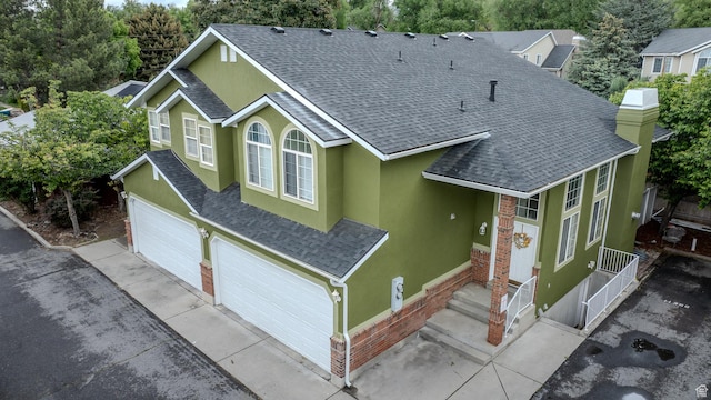 1140 E Elgin Ave S, Millcreek, UT 84106 - traditional home featuring stucco siding, a shingled roof, concrete driveway, and an attached garage