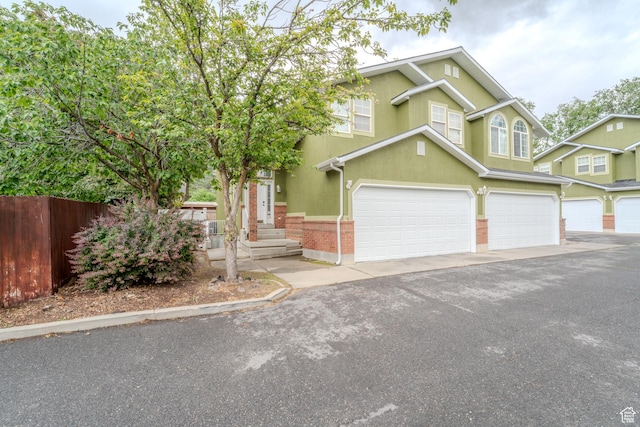 1140 E Elgin Ave S, Millcreek, UT 84106 - view of front of home with fence, stucco siding, an attached garage, and driveway