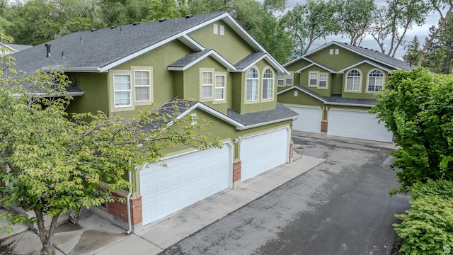 1140 E Elgin Ave S, Millcreek, UT 84106 - traditional home with roof with shingles, stucco siding, driveway, an attached garage, and brick siding