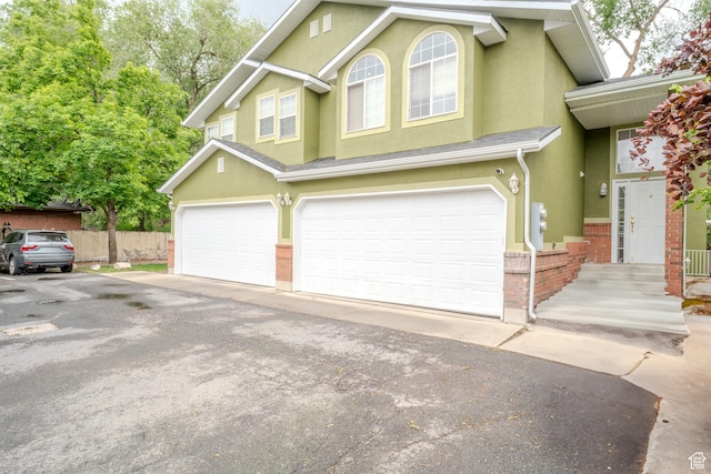 1140 E Elgin Ave S, Millcreek, UT 84106 - multi unit property featuring stucco siding, a garage, brick siding, asphalt driveway, and fence