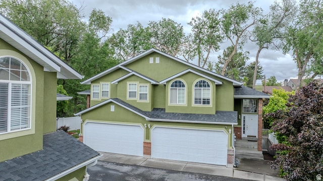 1140 E Elgin Ave S, Millcreek, UT 84106 - traditional-style house featuring a shingled roof, an attached garage, stucco siding, and brick siding