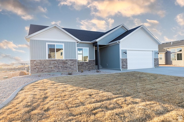 view of front of house featuring stone siding, a garage, board and batten siding, concrete driveway, and a front lawn