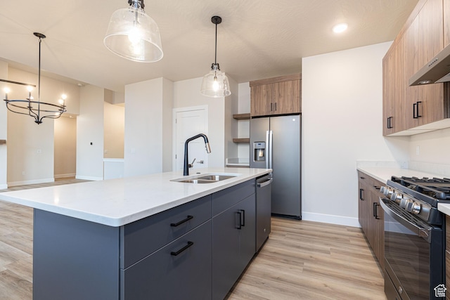 kitchen featuring a sink, appliances with stainless steel finishes, light wood finished floors, and light countertops