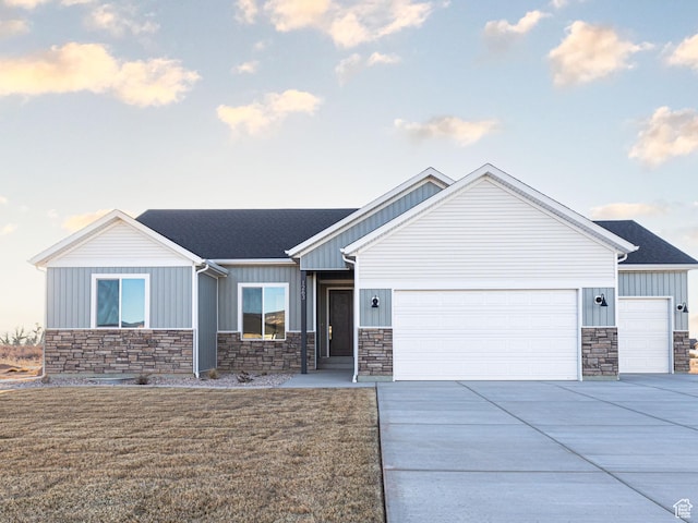 craftsman inspired home with stone siding, an attached garage, and board and batten siding