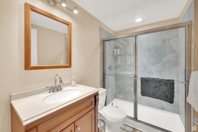 full bathroom with a shower stall, vanity, and toilet