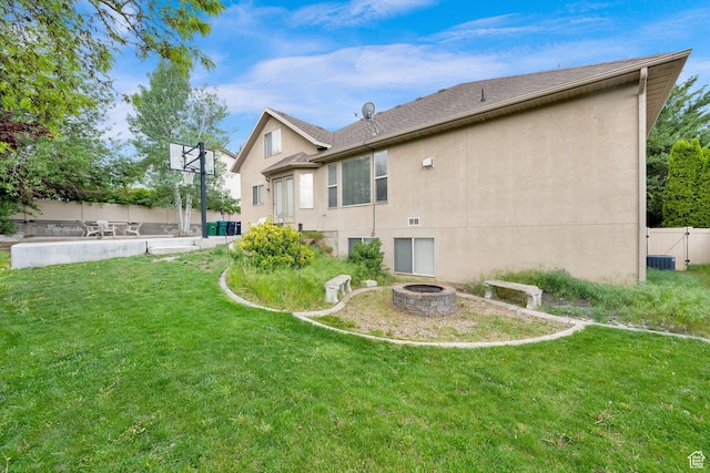 rear view of property featuring an outdoor fire pit and stucco siding