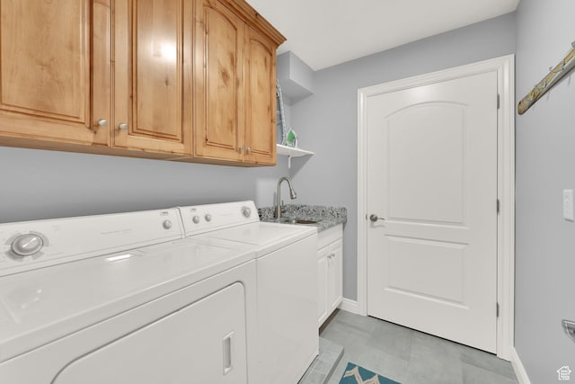 laundry room with washing machine and dryer, baseboards, and cabinet space