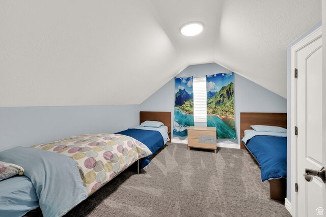 bedroom with carpet flooring, vaulted ceiling, and baseboards