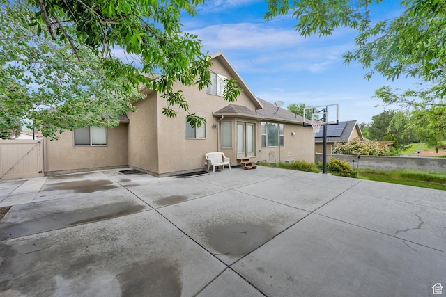back of property with stucco siding, entry steps, a patio area, fence, and a gate