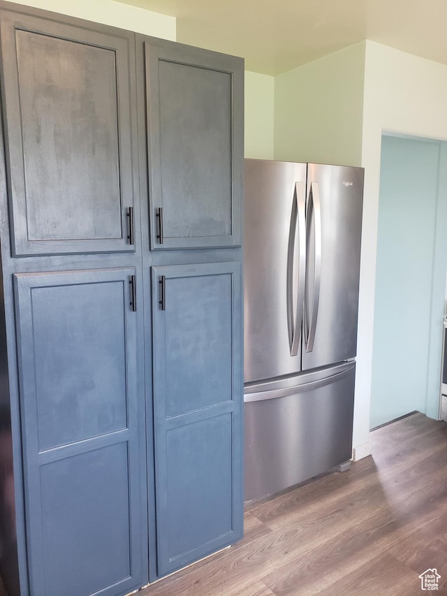 kitchen view of freestanding refrigerator and wood finished floors