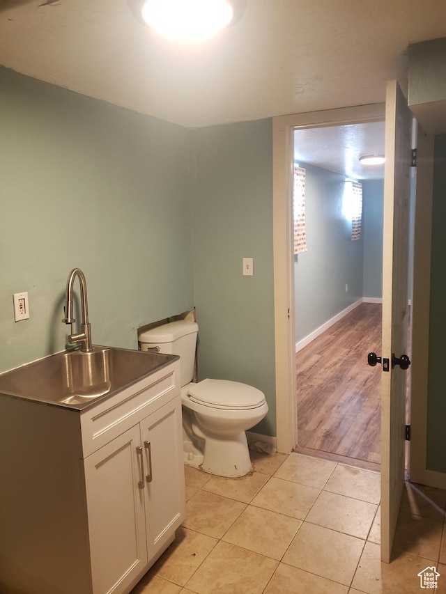 half bath featuring toilet, tile patterned floors, and vanity
