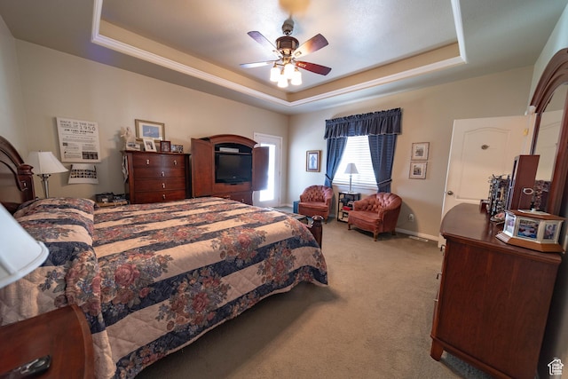 bedroom with a tray ceiling, carpet floors, a ceiling fan, and baseboards