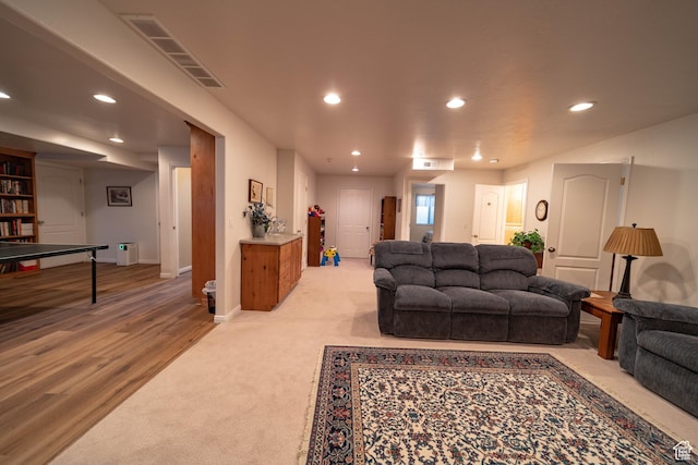 living area featuring recessed lighting, light carpet, baseboards, and light wood-style floors