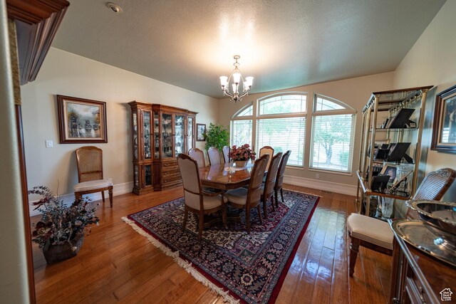 dining room featuring a chandelier, baseboards, and wood-type flooring