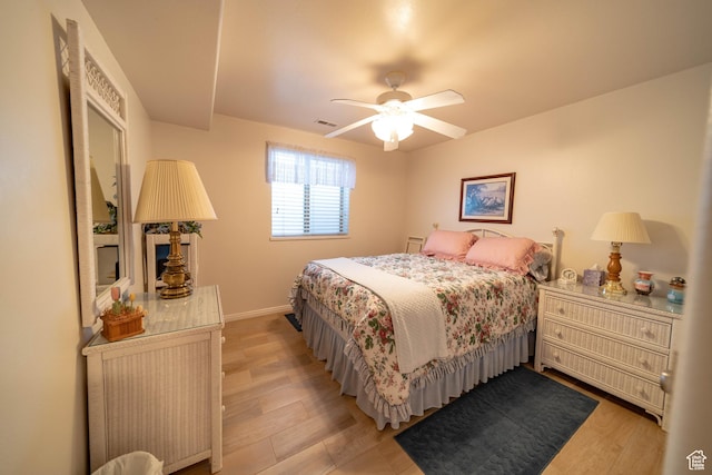 bedroom with light wood-type flooring, baseboards, and ceiling fan