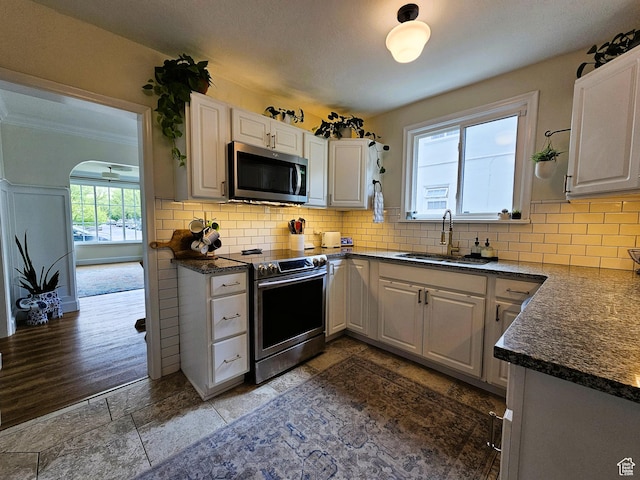 44 S 700 E, Provo, UT 84606 - kitchen featuring appliances with stainless steel finishes, a sink, backsplash, and white cabinetry