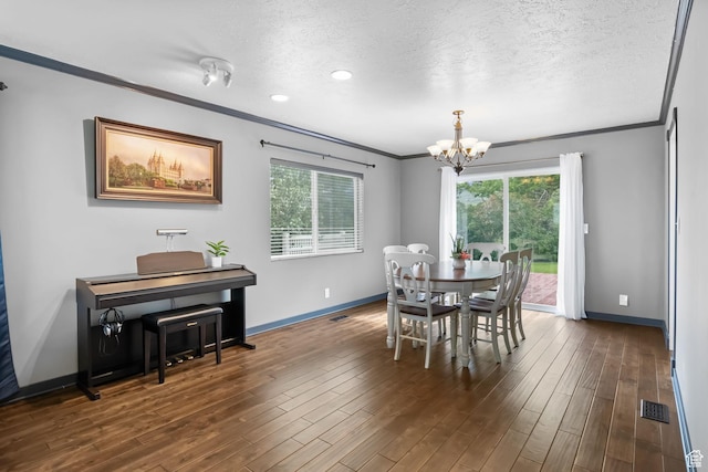 dining room featuring ornamental molding, a chandelier, baseboards, dark wood-type flooring, and a textured ceiling
