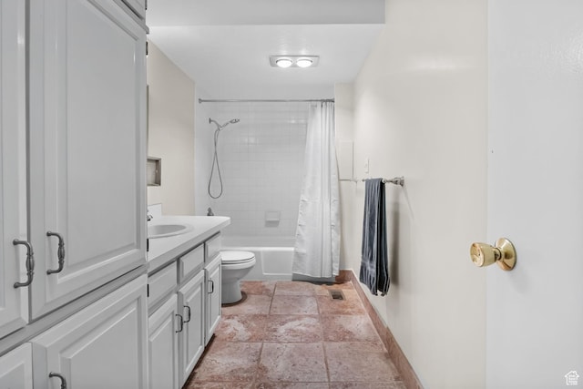 bathroom with baseboards, stone tile floors, toilet, shower / bath combination with curtain, and vanity