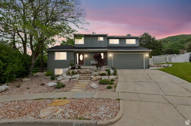 traditional-style house with fence, concrete driveway, a garage, and a porch