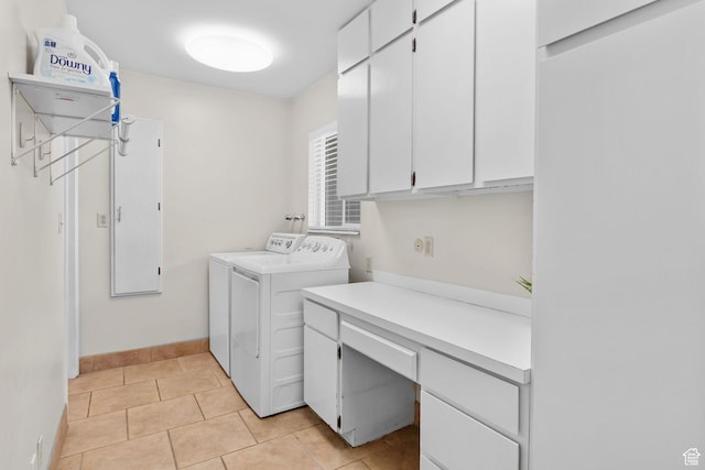 laundry area featuring cabinet space, independent washer and dryer, a desk, baseboards, and light tile patterned flooring