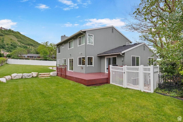 back of house featuring a chimney and a deck with mountain view