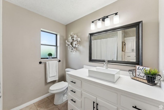 full bathroom featuring toilet, tile patterned floors, a textured ceiling, baseboards, and vanity