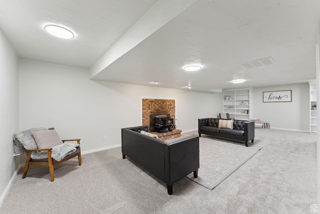 living room featuring carpet floors, a wood stove, baseboards, and a textured ceiling