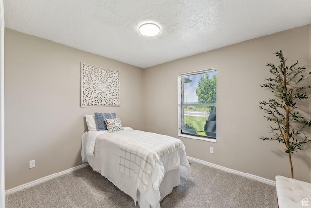 carpeted bedroom with baseboards and a textured ceiling
