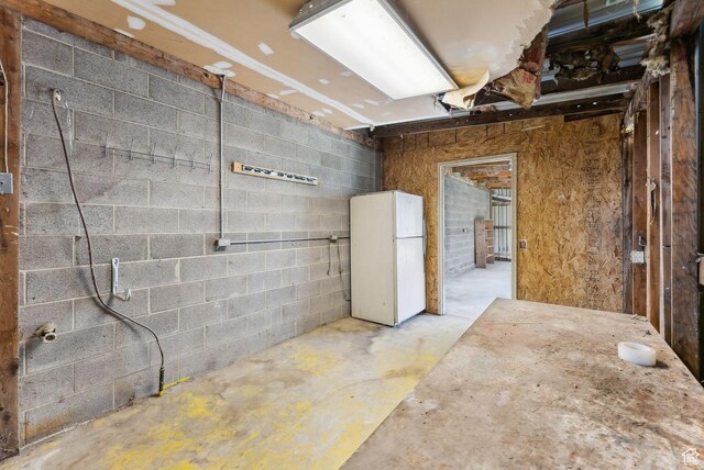misc room with concrete floors and concrete block wall