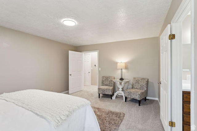 bedroom with light colored carpet, baseboards, and a textured ceiling