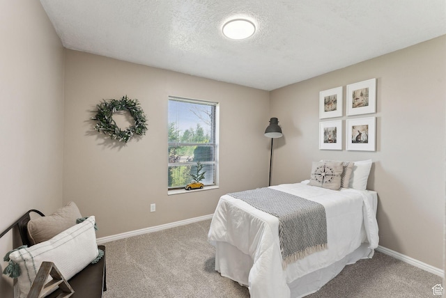 bedroom with carpet floors, baseboards, and a textured ceiling