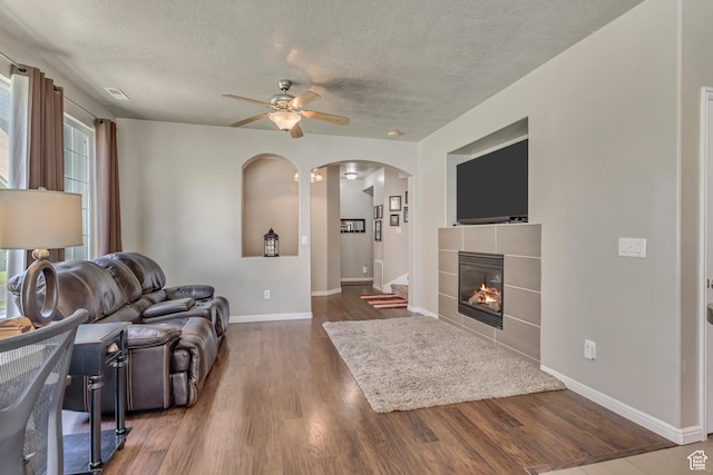 6297 W Traveler Ln, West Jordan, UT 84081 - living area featuring ceiling fan, arched walkways, baseboards, a textured ceiling, and wood finished floors