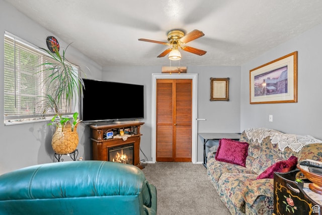 7472 S Silver Cir, West Jordan, UT 84084 - carpeted living room with ceiling fan, a glass covered fireplace, and baseboards